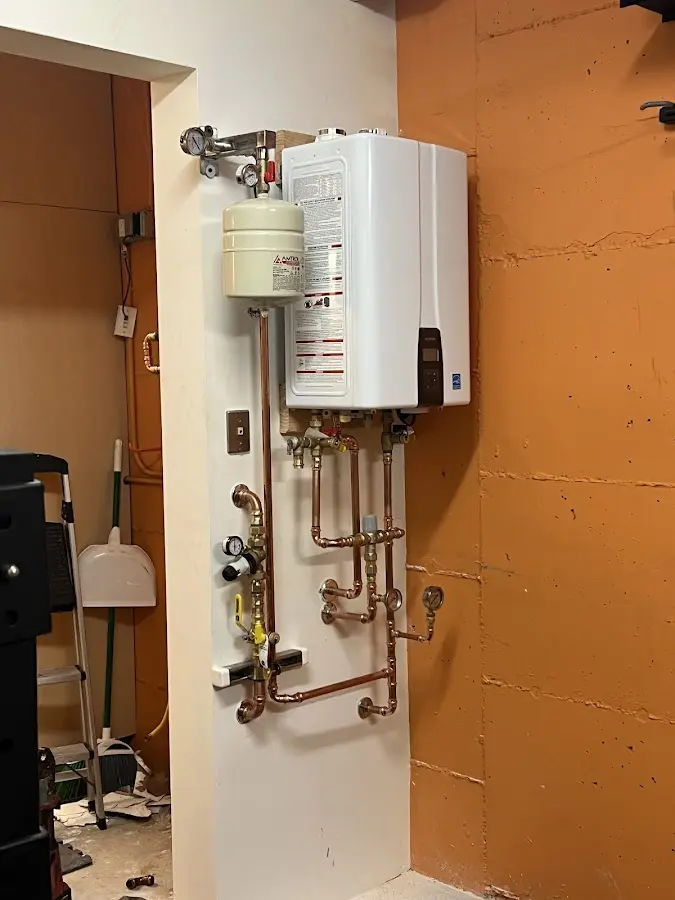 Plumbing technician inspecting water heater connections in Cleveland Heights